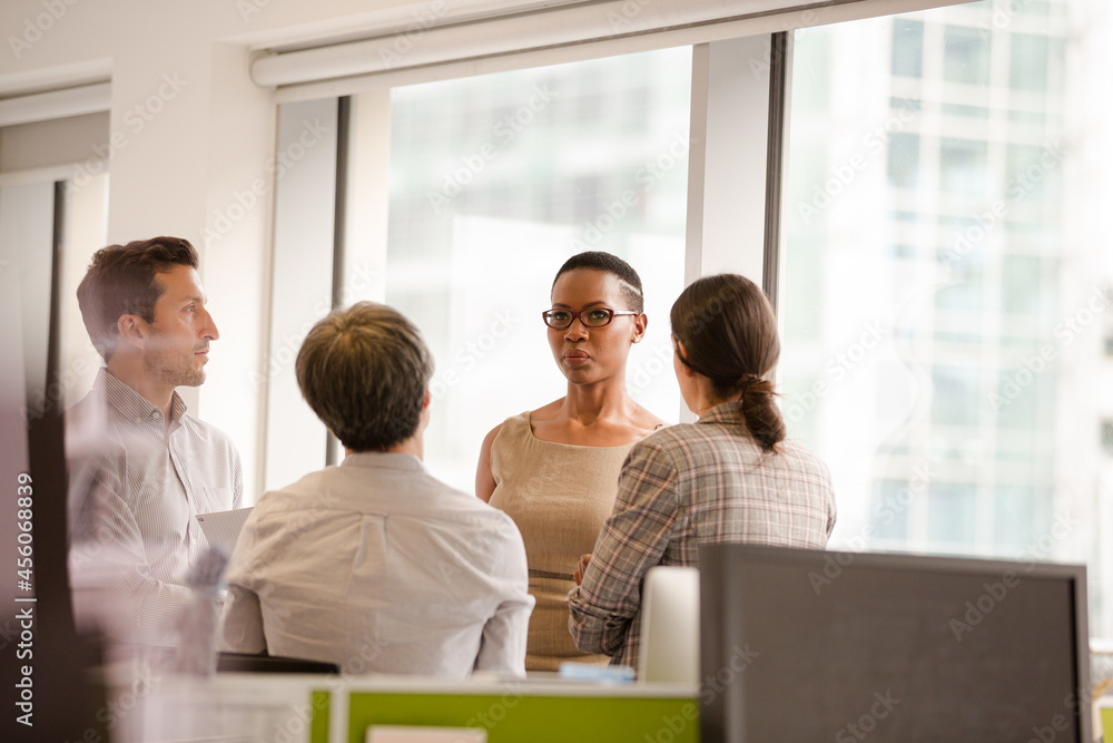 Business people talking in open plan office Business people talking in open plan office