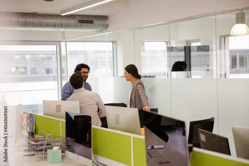 Business people talking in open plan office Business people talking in open plan office
