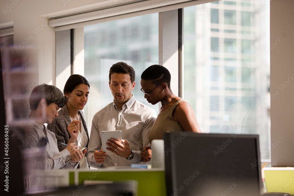 Business people talking in open plan office Business people talking in open plan office