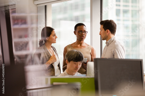 Business people talking in open plan office