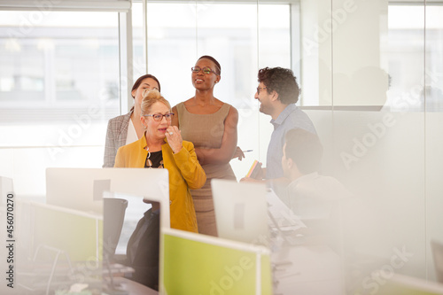 Business people talking in open plan office