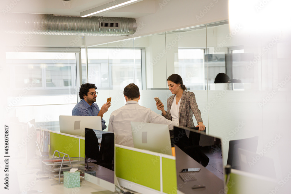 Business people talking in open plan office Business people talking in open plan office
