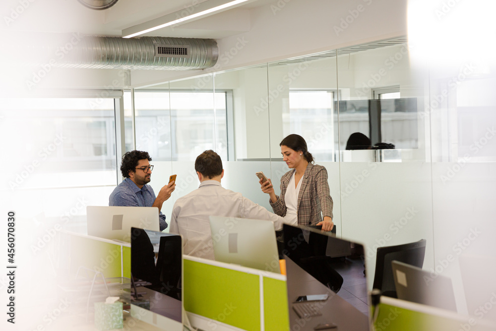 Business people talking in open plan office Business people talking in open plan office