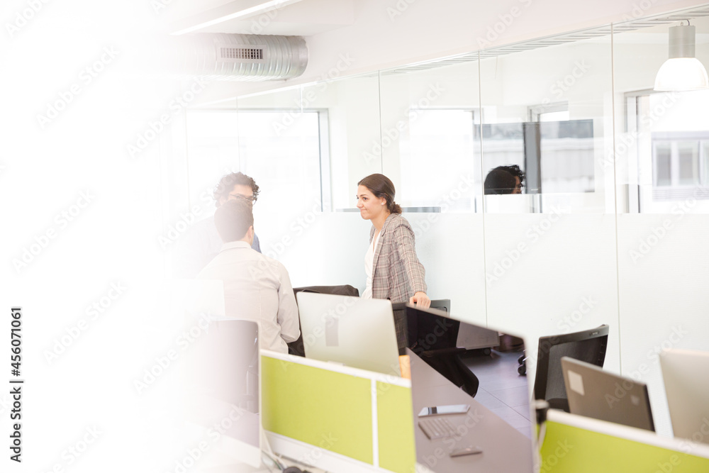 Business people talking in open plan office Business people talking in open plan office