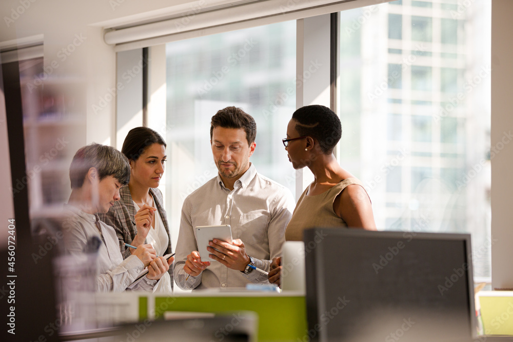 Business people talking in open plan office Business people talking in open plan office