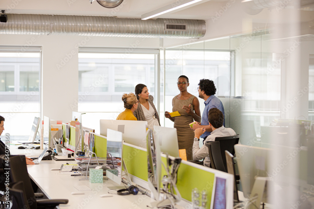 Business people talking in open plan office Business people talking in open plan office