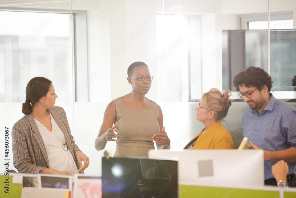 Business people talking in open plan office Business people talking in open plan office