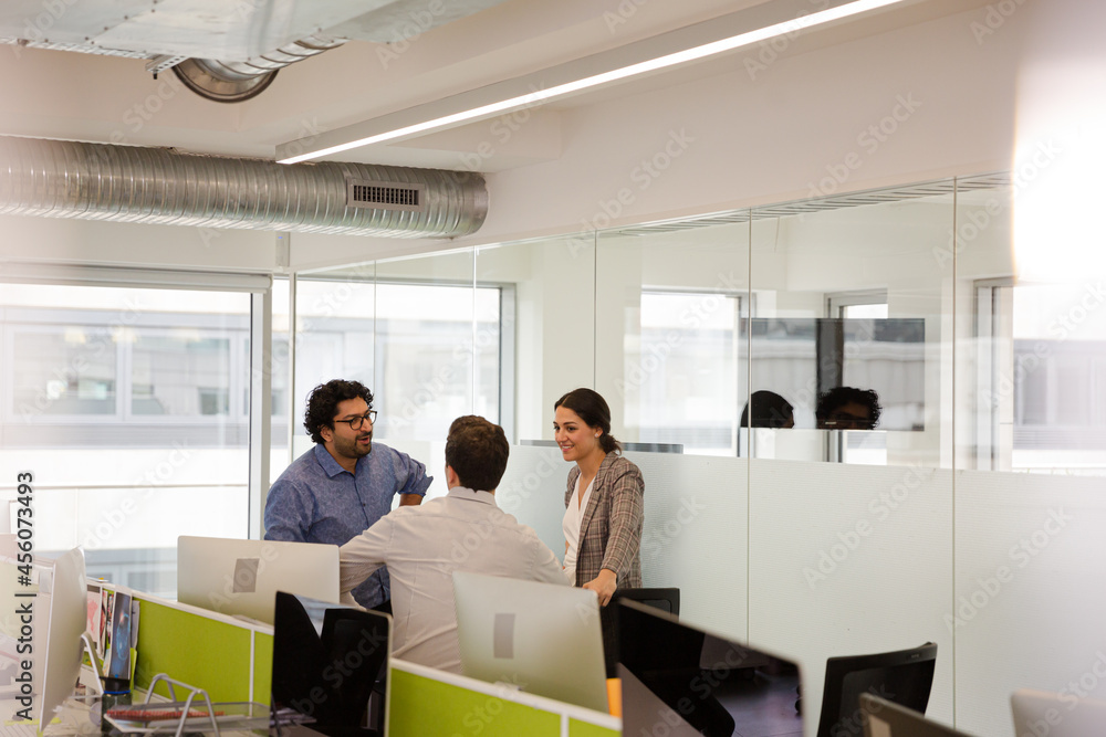 Business people talking in open plan office Business people talking in open plan office