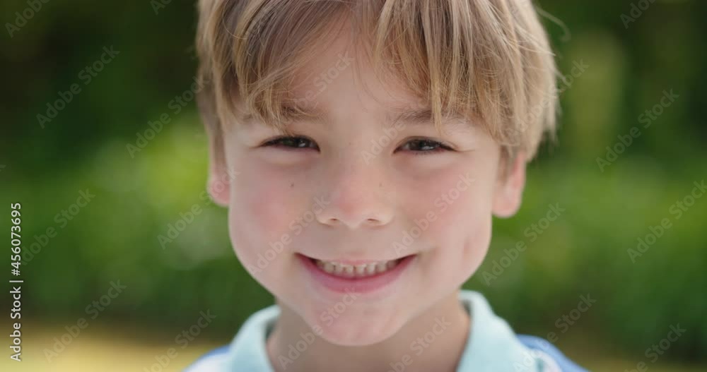 portrait happy little boy smiling with playful excitement looking at camera enjoying childhood fun in sunny park 4k footage portrait happy little boy smiling with playful excitement looking at camera enjoying childhood fun in sunny park 4k footage