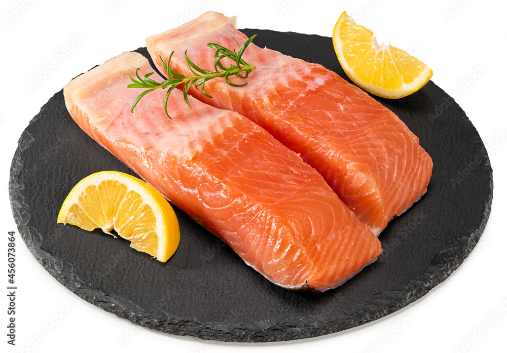 Red fish. Raw salmon fillet with rosemary and lemon on black round stone plate isolate on white background. Clipping path and full depth of field. Red fish. Raw salmon fillet with rosemary and lemon on black round stone plate isolate on white background. Clipping path and full depth of field.