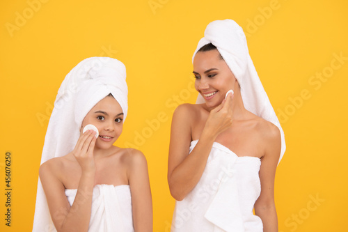 mother and daughter use cotton pads taking off makeup cleaning face, beauty treatment.