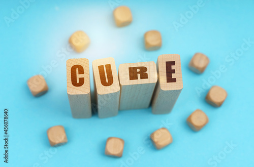 On a blue background, wooden cubes and Jenga with the inscription - CURE