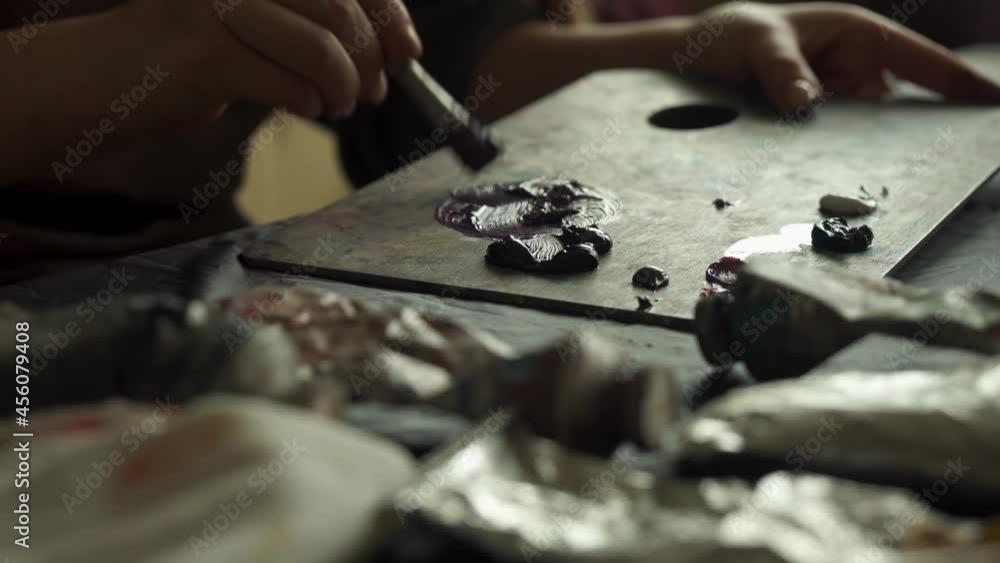 The girl mixes paints on the palette. Begins to paint a picture The girl mixes paints on the palette. Begins to paint a picture