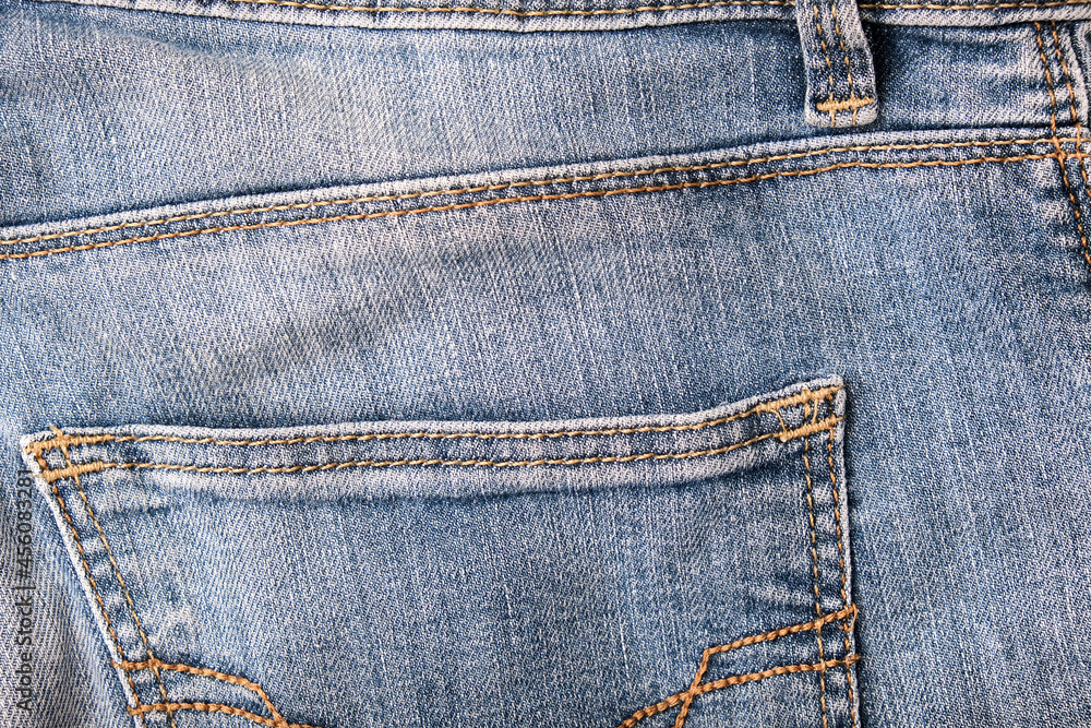 Blue shabby jeans back pockets close up