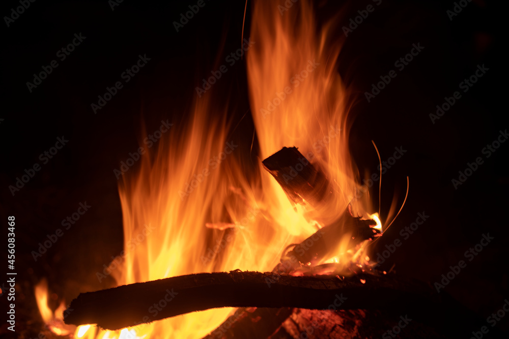Bonfire flame at night. Yellow fire in the dark. Burning dry branches in a bright fire. Bonfire flame at night. Yellow fire in the dark. Burning dry branches in a bright fire.