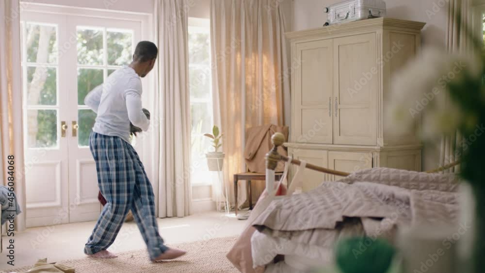 funny african american man dancing in bedroom having fun celebrating feeling positive enjoying successful lifestyle doing silly dance at home on weekend morning wearing pajamas funny african american man dancing in bedroom having fun celebrating feeling positive enjoying successful lifestyle doing silly dance at home on weekend morning wearing pajamas
