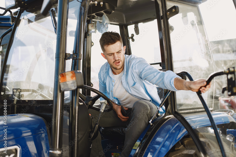 Male sitting comfortably on a big blue tractor Male sitting comfortably on a big blue tractor