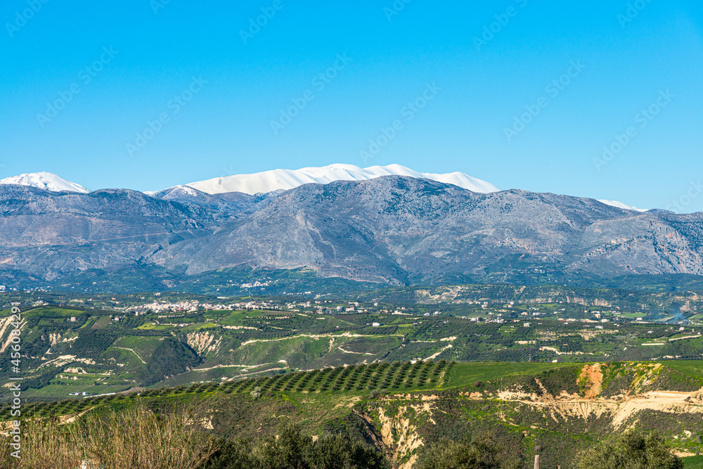 Aerial view of rural Heraklion region landscape. Unique alpine scenic panorama Olive groves, vineyards, green meadows and hills view in spring. Psiloritis montain in background. Heraklion, Crete Aerial view of rural Heraklion region landscape. Unique alpine scenic panorama Olive groves, vineyards, green meadows and hills view in spring. Psiloritis montain in background. Heraklion, Crete
