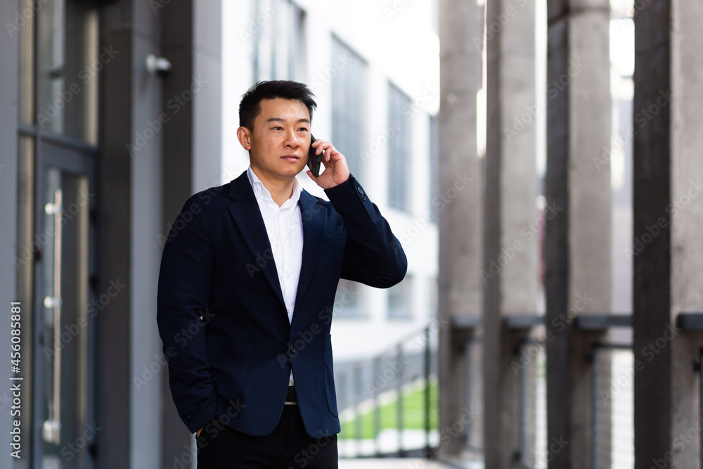 Asian businessman talking on the phone serious has an angry conversation Asian businessman talking on the phone serious has an angry conversation