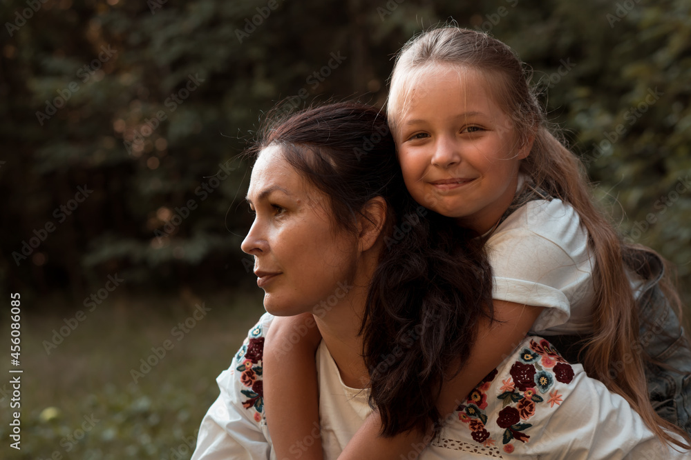 Naklejka premium mother and daughter hugging in park or forest