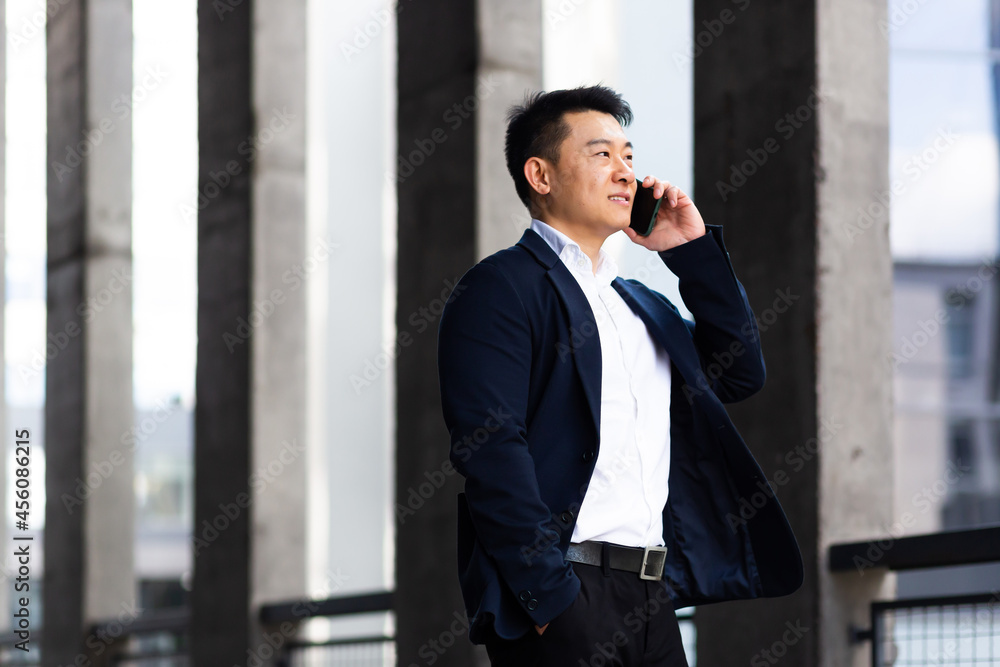Asian businessman talking on the phone serious has an angry conversation Asian businessman talking on the phone serious has an angry conversation