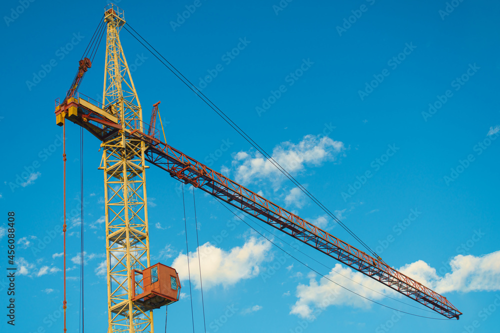 High industrial tower crane at construction site of new residential building.