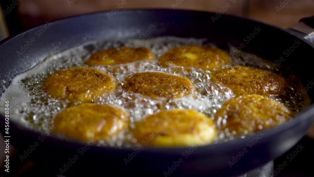 Making authentic deep fried potato balls in the kitchen. Close-up on delicious vegetarian food. Shallow depth of field with selective focus.