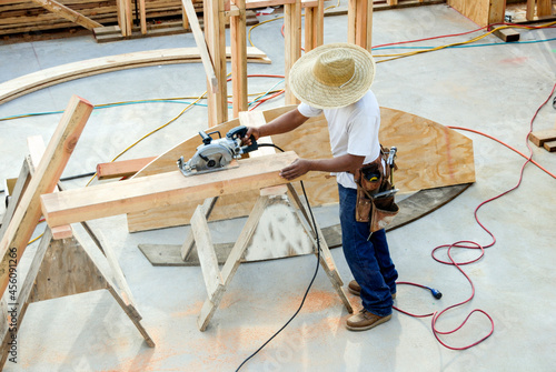 Carpenter rip-cutting a wood beam with a circular saw