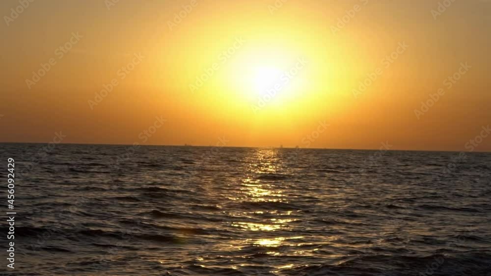 Slowmotion sun sparkles on gently rippling ocean surface, sunlight reflecting on ocean calm water. Sunset to south of Spain. Golden sky with sundown. Natural scenic dramatic warm colorful horizon-Dan Slowmotion sun sparkles on gently rippling ocean surface, sunlight reflecting on ocean calm water. Sunset to south of Spain. Golden sky with sundown. Natural scenic dramatic warm colorful horizon-Dan
