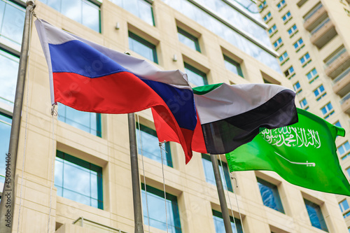 United Arab Emirates and Russia flag waving against building