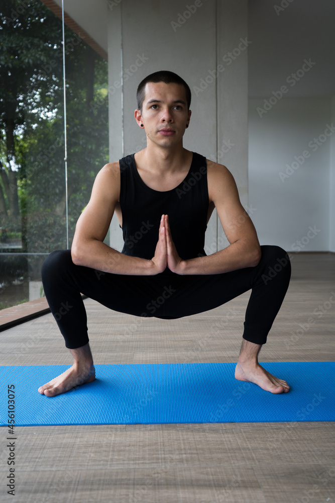man in black sportswear practicing yoga in various poses in a blue mat man in black sportswear practicing yoga in various poses in a blue mat