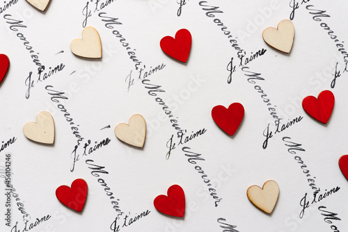 wooden hearts - some hand painted red - on a white background with the french words 