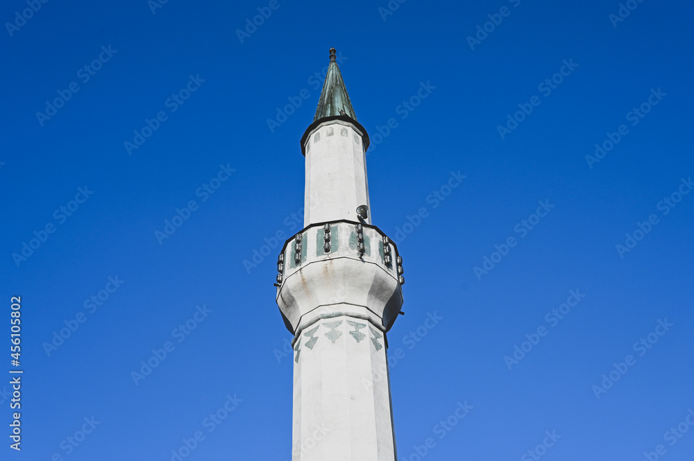Minaret near mosque against blue sky.  