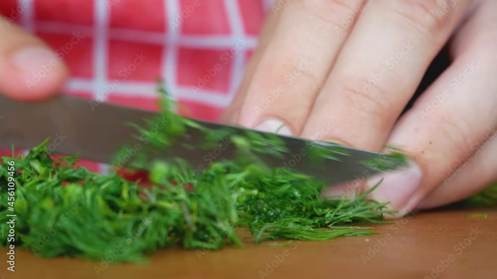 Chopped bunch of dill with knife on wooden kitchen board. Preparing fresh organic vegetable salad in kitchen at home. Healthy herb leaf Chopped bunch of dill with knife on wooden kitchen board. Preparing fresh organic vegetable salad in kitchen at home. Healthy herb leaf