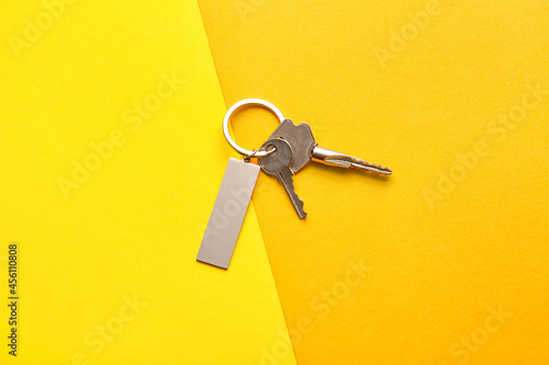 Keys with stylish keychain on color background