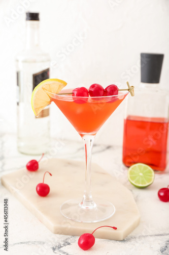 Glass of tasty cosmopolitan cocktail on light background © Pixel-Shot