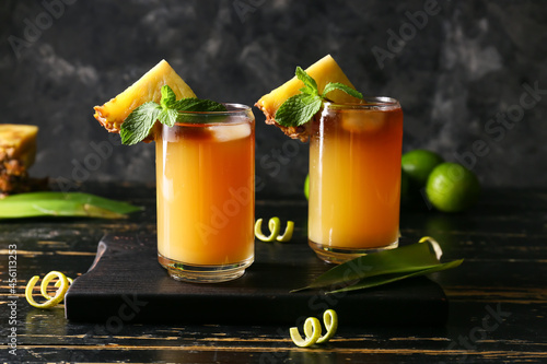 Glasses of tasty mai tai cocktail on dark background photo