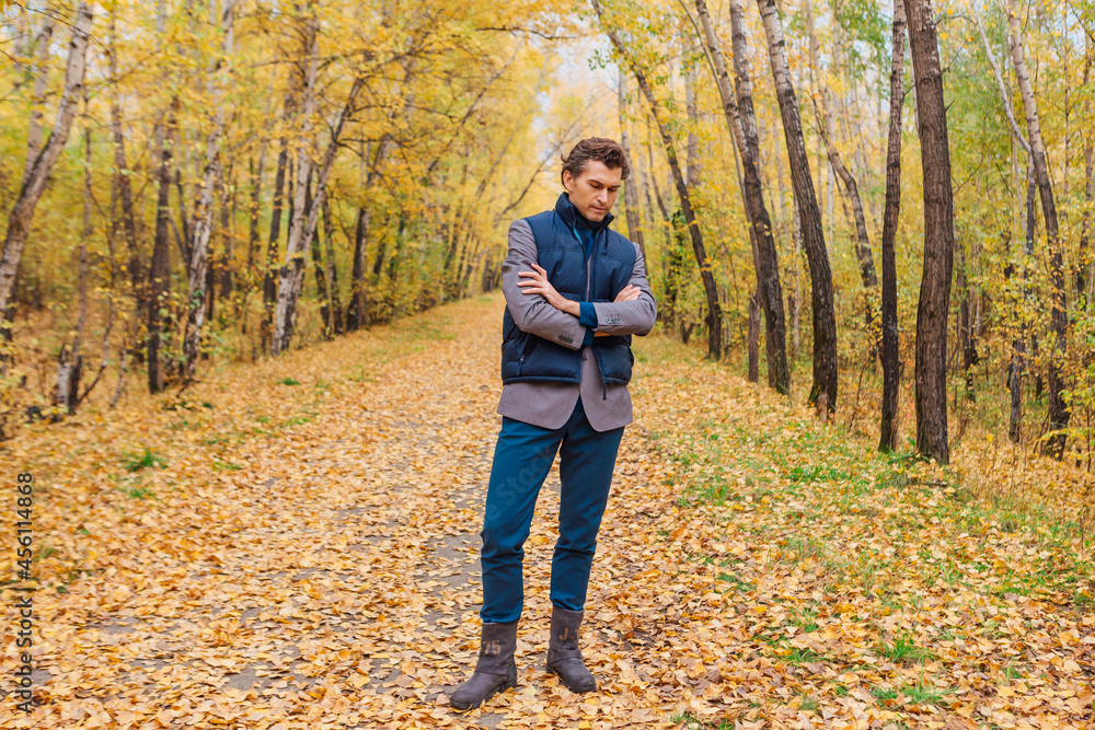 Tall handsome man walking in the autumn alley Tall handsome man walking in the autumn alley