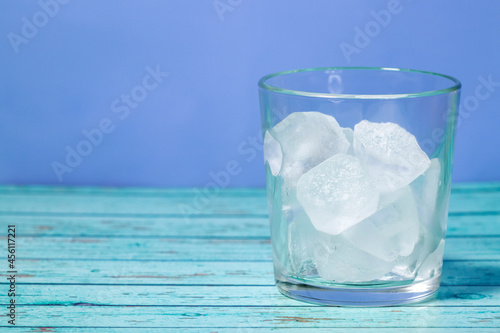 ice cubes in glass on blue background