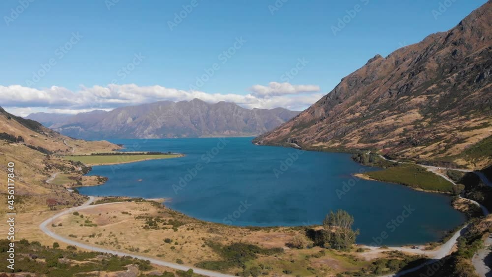Aerial drone shot of a blue majestic lake surrounded by mountains in New Zealand on sunny summer day in 4k. Aerial drone shot of a blue majestic lake surrounded by mountains in New Zealand on sunny summer day in 4k.
