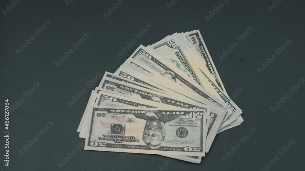 A bundle of dollar bills falls on a black table. Close-up. High quality 4k footage A bundle of dollar bills falls on a black table. Close-up. High quality 4k footage