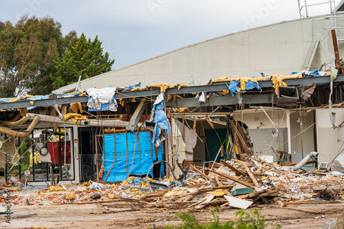Horizontal shot of a partly demolished house with wood waste scraps and building material