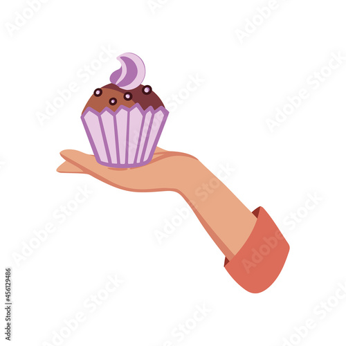 Female hand with tasty cupcake, Hand holding a cupcake with pink buttercream.