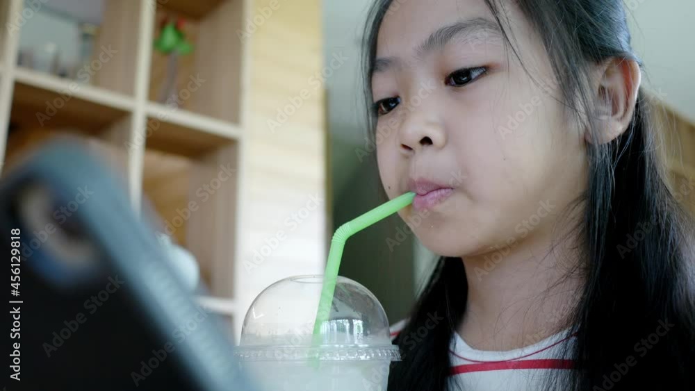 Children drinking cool sweet water and plat games online in tablet Children drinking cool sweet water and plat games online in tablet