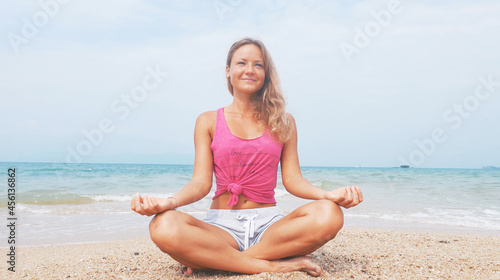 Woman doing meditation near the ocean beach. Yoga silhouette.