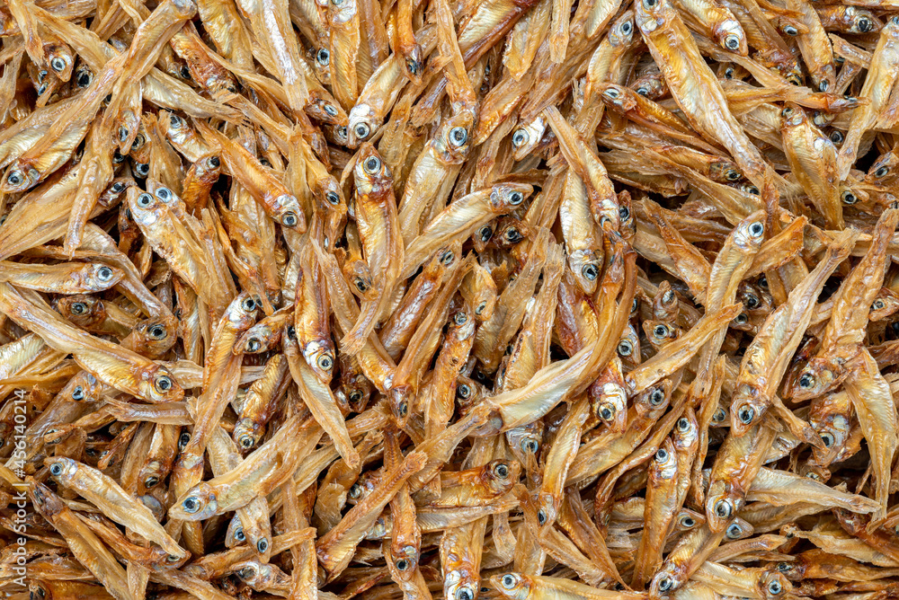 Dried anchovies fish on white background, macro image, fill frame with brown dried anchovies.