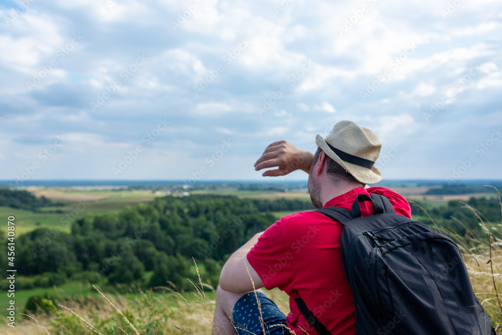 Man with backpack hiking wipe the sweat and hold the water bottle on the mountain forest. Backpack travel concept. Man with backpack hiking wipe the sweat and hold the water bottle on the mountain forest. Backpack travel concept.