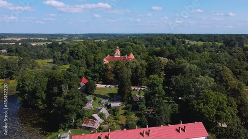 Aerial View of Edole Village, Edole Medieval Castle and Lake in Sunny Summer, Latvia, Courland (Kurzeme), Western Latvia. History, Architecture, Travel Destinations, National Landmark photo