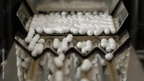 Pharmaceutical production. Medical capsules are moving in a packaging machine. Slowmotion 120 fps.