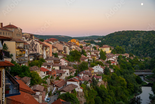 Houses with red tiled roofs , built on a mountain . © FO_DE